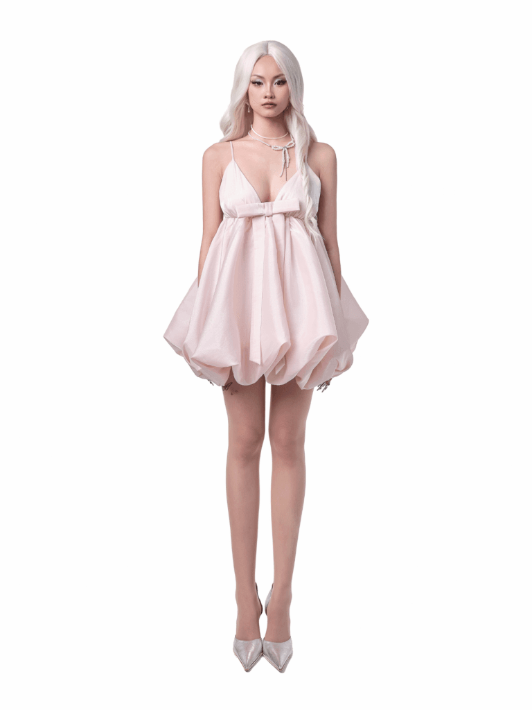 Model wearing WABI DRESS – pastel pink bubble skirt birthday dress with bow detail
