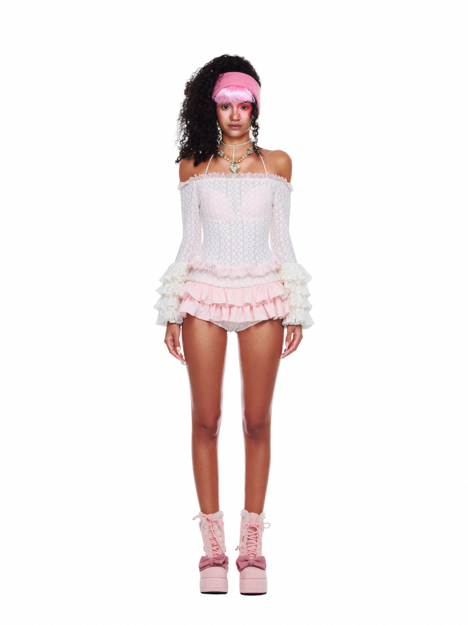 Model wearing Bubbly Bay Set with off-shoulder lace top and tiered pink ruffle shorts, styled for feminine summer wear