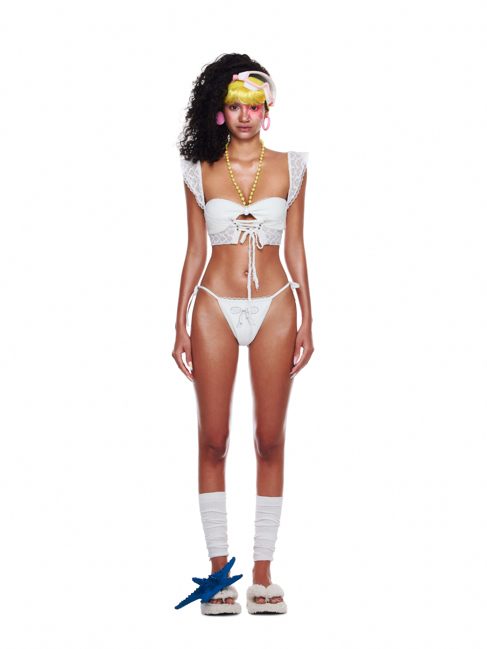 Model wearing Azure Set — a white lace bikini top with flutter sleeves and crystal details, styled as elegant beachwear clothing for summer festivals or vacations.