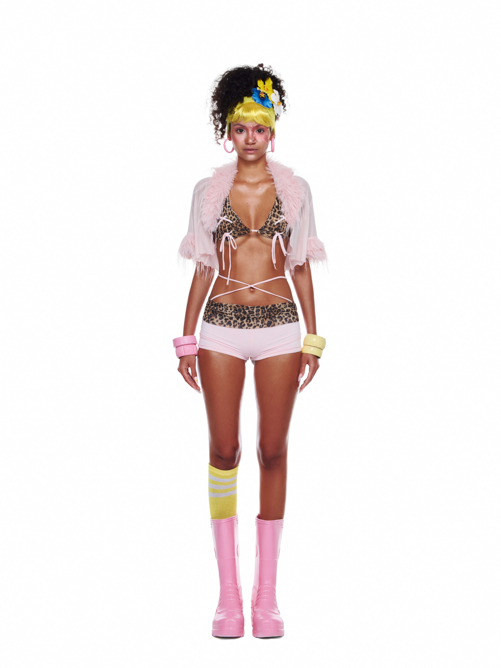 Model wearing Étoilie Set featuring a leopard bikini top, pink faux fur shrug, and cotton shorts as a playful beach outfit
