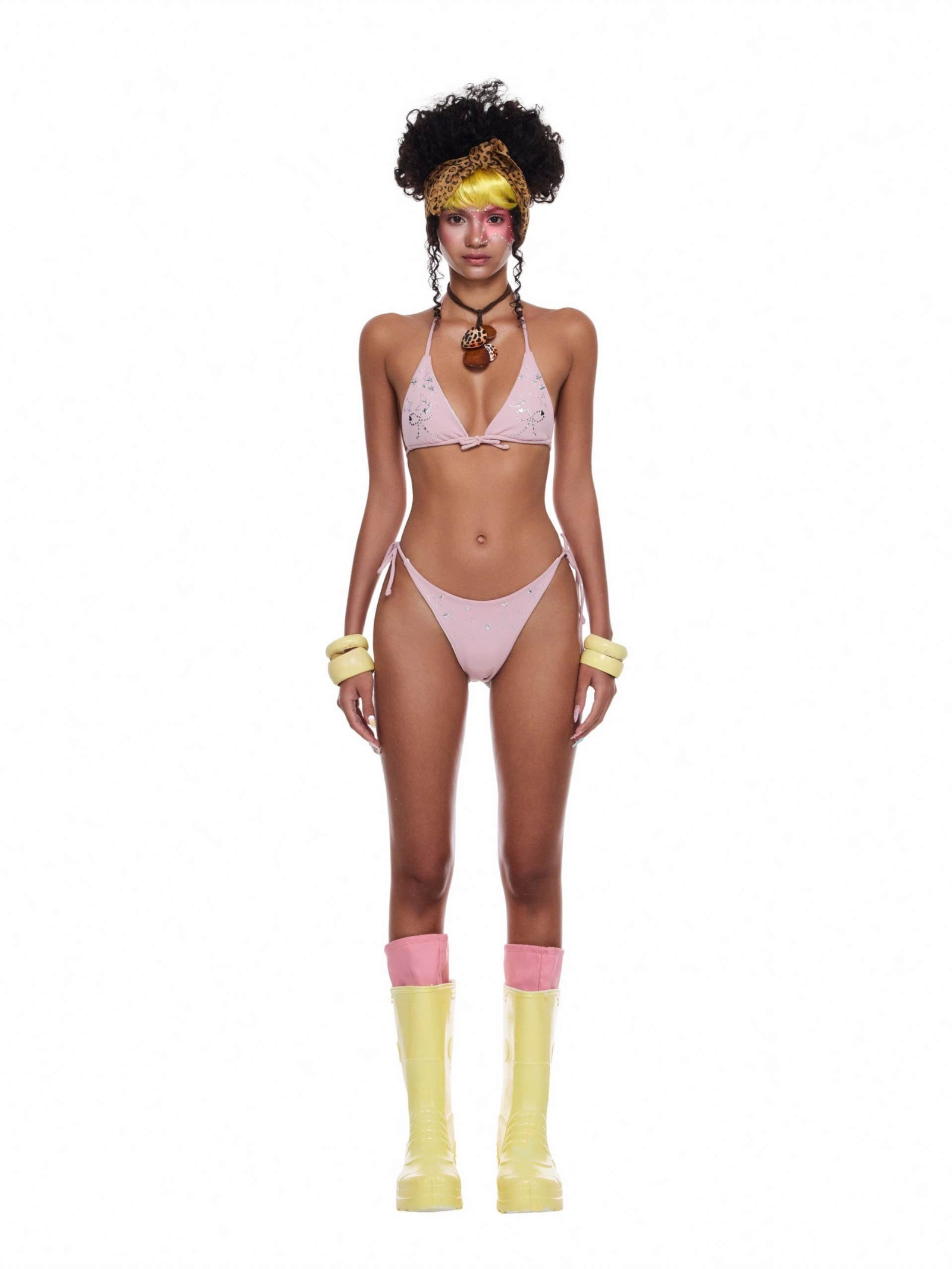 Model wearing the Tulle Tide Set – a sparkly crystal bikini beach outfit with yellow boots and statement accessories.